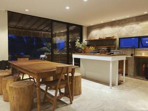a kitchen with a wooden table and wooden stools at Beach House Brazil in Amontada