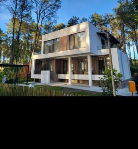 a large white house with trees in the background at Leto by Sveta in Ureki