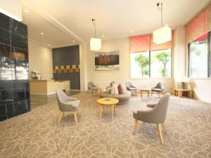 a lobby with a waiting room with chairs and tables at 伊豆長岡温泉 ホテル茜 in Izunokuni