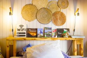 un estante con libros y sombreros de paja en una pared en Chez Cathy chambre chez l'habitante, en Bremis