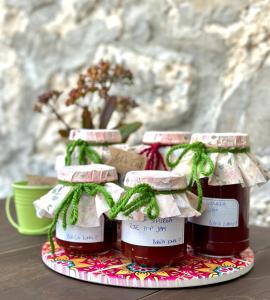 three bottles of honey on a plate on a table at Bobića konak - Lukomir in Lukomir +85 photos