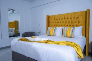 a bedroom with a large bed with a yellow blanket on it at De Lux Villa in Bulawayo +78 photos