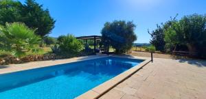Una gran piscina en un patio con árboles. en Le jardin du Grand Chemin, en Baron