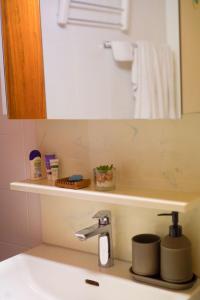 y baño con lavamanos, espejo y lavamanos. en Chez Cathy chambre chez l'habitante, en Bremis 10 fotos más