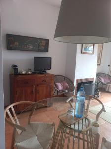 a living room with a glass table with a bottle on it at Olhando um Campo de Golf in Islantilla