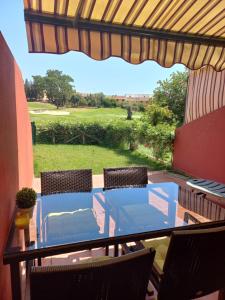 a patio with a table and chairs and a view of a golf course at Olhando um Campo de Golf in Islantilla