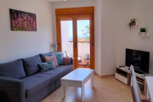 a living room with a blue couch and a table at Guadalest Panorama in Guadalest