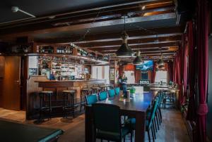 a restaurant with a table and chairs and a bar at Hotel de Harmonie in Sexbierum