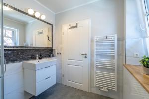 a white bathroom with a sink and a mirror at Rehburger Landhaus in Rehburg-Loccum +56 photos