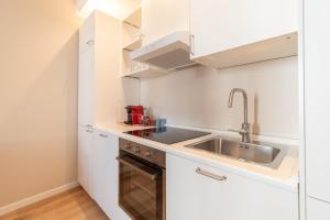a small kitchen with white cabinets and a sink at Arnaldo Cozy Home Stay Central with Piazza View in Brescia