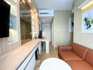 a living room with a couch and a table at Great Choice and Comfort Stay 2BR at Patraland Urbano Apartment By Travelio in Bekasi