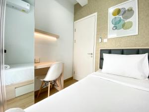 a bedroom with a white bed and a desk at Great Choice and Comfort Stay 2BR at Patraland Urbano Apartment By Travelio in Bekasi +13 photos