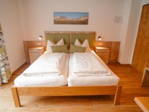 a bedroom with a bed with white sheets and pillows at Apartment Furrach by Interhome in Donnersbach