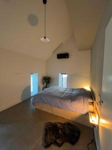 a bedroom with a bed in a room with windows at Gastenverblijf 'tsiishokje' in Lioessens