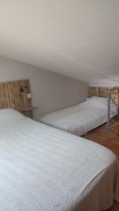deux lits dans une chambre avec des draps blancs dans l'établissement Chez Isa et Ray, un gîte en Provence, à Châteaurenard