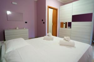 a bedroom with a white bed with two towels on it at Maccuro Luxury Apartment in Vibo Valentia Marina