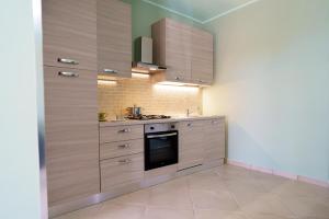a kitchen with wooden cabinets and a stove at Maccuro Luxury Apartment in Vibo Valentia Marina