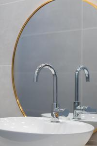 a sink with two faucets in a bathroom at PORT CITY HAIFA - Beach Front Penthouse Bat Galim - MAMAD in Haifa