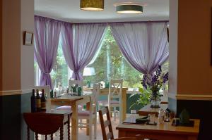 a dining room with a table and purple curtains at Atholl House Skye in Dunvegan