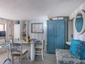 a dining room with a table and a blue cabinet at Apartment La Chicca by Interhome in Castiglioncello