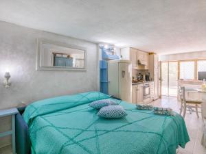a bedroom with a blue bed with two pillows on it at Apartment La Chicca by Interhome in Castiglioncello