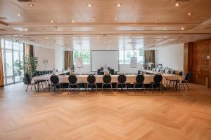 ein großes Zimmer mit Tischen und Stühlen und einer Leinwand in der Unterkunft Arkona Strandhotel in Binz + 37 Fotos