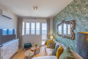 Una sala de estar con un sofá y un espejo. en El Mirador de Julia, en Santa Cruz de la Palma