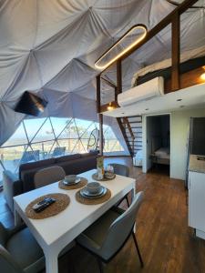 a dining room with a white table and chairs at The Domes Jarabacoa in Jarabacoa
