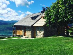 a stone house on a hill with green grass at Kuća za odmor Vidikovac in Rumboci