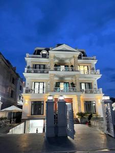 a large white building with a lot of windows at Villa 13 phòng ngủ vip - Đầy đủ tiện nghi - Bể bơi riêng - Bàn Bi a in Ha Long