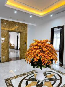 a vase filled with orange flowers in a lobby at Villa 13 phòng ngủ vip - Đầy đủ tiện nghi - Bể bơi riêng - Bàn Bi a in Ha Long