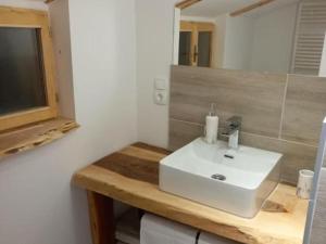 une salle de bain avec un lavabo blanc et un miroir dans l'établissement Kuća za odmor Vidikovac, à Rumboci 49 autres photos