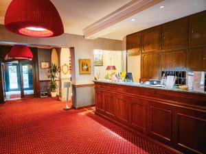 un ristorante con bar e tappeto rosso di Hotel Bel Air Trail & Wellness a Echternach
