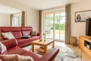 ein Wohnzimmer mit einem roten Sofa und einem Fernseher in der Unterkunft An den Eichen 1 in Wieck