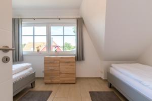 1 Schlafzimmer mit 2 Betten, einer Kommode und einem Fenster in der Unterkunft An den Eichen 1 in Wieck
