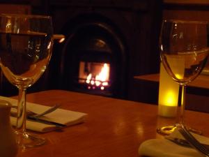 two wine glasses sitting on a table with a fireplace at The Park Hotel in Dunoon
