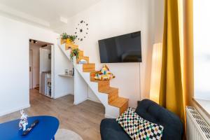 a living room with a staircase with a tv at D52 - DAS BUSINESSAPARTMENT --- 2 Minuten vom Flughafen entfernt in Dresden