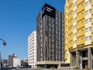 een hoog gebouw met een bord aan de zijkant bij Comfort Hotel Nagoya Shinkansenguchi in Nagoya