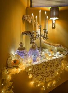 a table with candles and vases on it with lights at Pino - Villa, Casa, Cucina е Terrazza in Albena