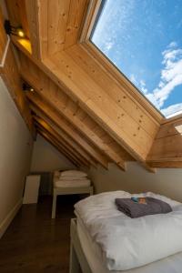 a bed in a room with a large skylight at Vert Lodge Chamonix in Chamonix-Mont-Blanc