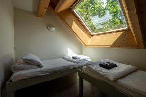 two beds in a room with a large window at Vert Lodge Chamonix in Chamonix-Mont-Blanc