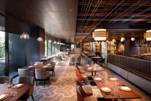 a restaurant with wooden tables and chairs and a bar at Hilton Kyoto in Kyoto