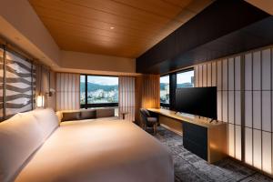 a bedroom with a large bed and a television at Hilton Kyoto in Kyoto