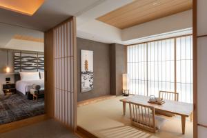 a bedroom with a bed and a desk and a table at Hilton Kyoto in Kyoto