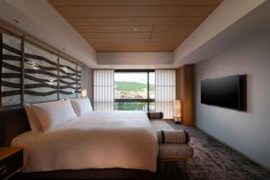 a bedroom with a large bed and a television at Hilton Kyoto in Kyoto