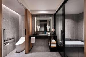 a bathroom with a tub and a sink and a toilet at Hilton Kyoto in Kyoto