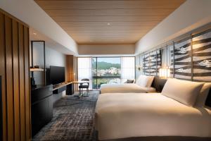 a hotel room with two beds and a television at Hilton Kyoto in Kyoto