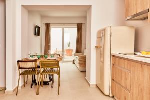 a kitchen with a table with chairs and a refrigerator at LUPERCAS in Mérida