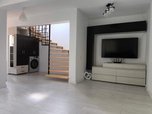 a living room with a staircase and a flat screen tv at Ola's House in Bradu
