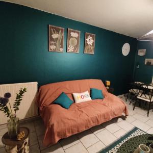 a bedroom with a bed with orange sheets and blue walls at Au nid carolo in Charleville-Mézières +52 photos
